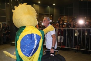 Tite é saudado pela mascote Canarinho na chegada da seleção a Moscou – local do jogo com a Sérvia Foto: CBF  